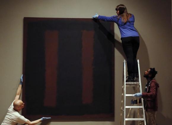 Tate staff pose with the restored Mark Rothko artwork "Black on Maroon, 1958" at the Tate Modern in London